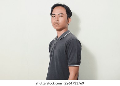 portrait of a smiling or flat asian man looking at the camera. portrait of indonesian man in black shirt on isolated white background - Powered by Shutterstock