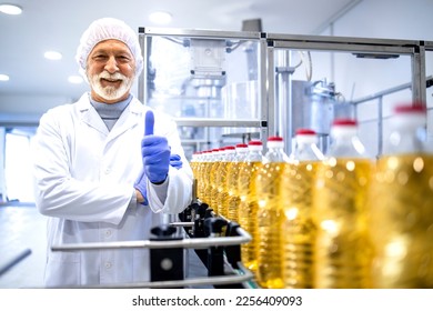 Portrait of smiling food factory worker holding thumb up for successful production. - Powered by Shutterstock