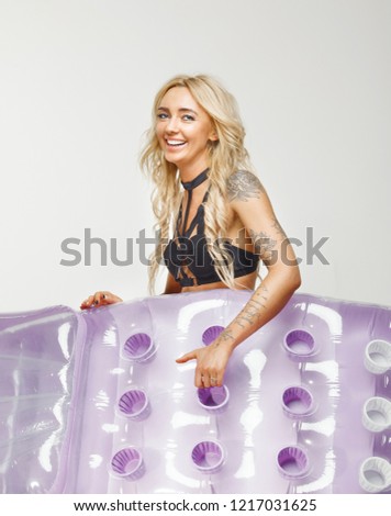 Portrait of smiling girl in bathing suit with mattress hand over white isolated.