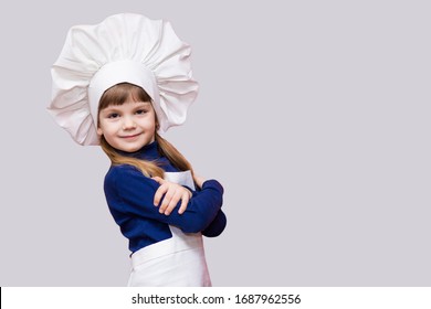 Portrait Of Smiling Girl Chef In Uniform With Cross Hands Isolated On White Background. Kid Chef. Cooking Process Concept