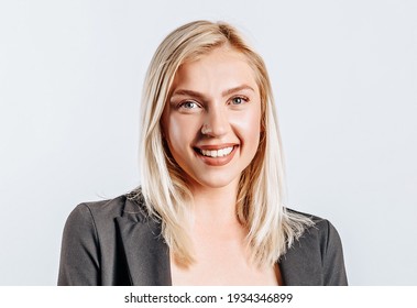Portrait of a smiling girl pointing finger up at copyspace isolated on a white background. A woman points to an idea, a place for advertising. Positive blonde.