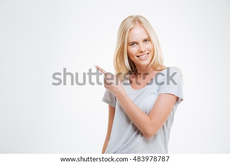 Portrait of a smiling girl pointing finger away isolated on a white background