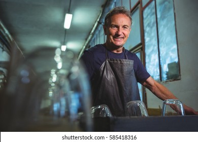 Portrait of smiling glassblower standing in glass blowing factory - Powered by Shutterstock