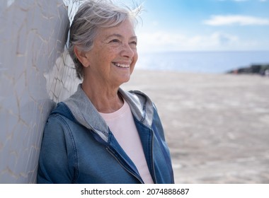 Portrait Of Smiling Gray Haired Senior Woman In Outdoor Excursion At Sea. Horizon Over Water And Blue Sky