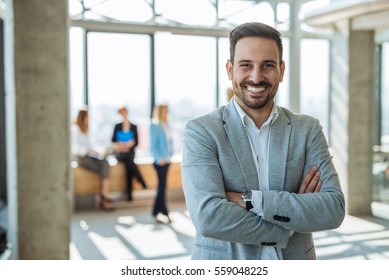 Portrait of a smiling handsome businessman with crossed arms.