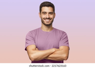 Portrait smiling handsome man in purple t  shirt standing and crossed arms isolated purple gradient background