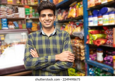 Portrait of smiling handsome young Indian man standing cross arm at grocery shop or supermarket, Closeup. Selective Focus. - Powered by Shutterstock