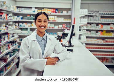 Portrait of smiling happy confident young woman pharmacist leaning on a desk in the pharmacy