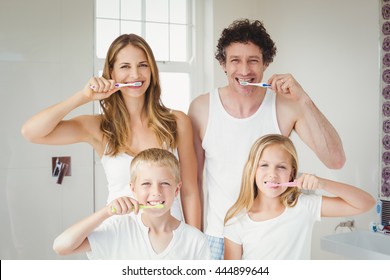 Portrait of smiling happy family brushing teeth at home