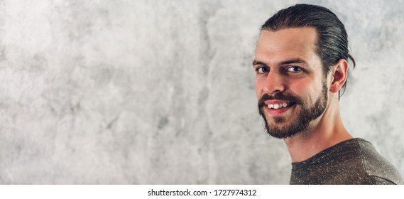 Portrait Of Smiling Happy Handsome Bearded Hipster Man Model With Copy Space Banner For Adding Text On White Wall Background