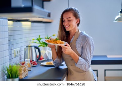 Portrait of smiling happy joyful cute cooking woman chef wearing apron holding a pasta plate for dinner