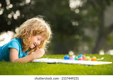 Portrait Of Smiling Happy Kid Enjoying Art And Craft Drawing In Backyard Or Spring Park. Happy Child Playing Outside. Drawing Summer Theme. Imagination Kids Concept.