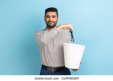 Portrait of smiling happy satisfied businessman throwing out his optical glasses after vision treatment, looking at camera, wearing striped shirt. Indoor studio shot isolated on blue background. - Shutterstock ID 2149985609