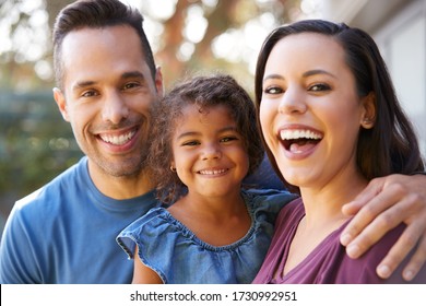 Portrait Of Smiling Hispanic Family With Daughter Laughing In Garden At Home - Shutterstock ID 1730992951