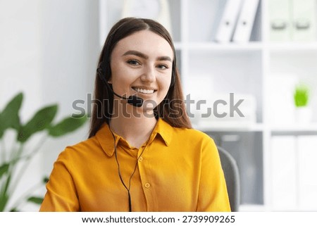 Portrait of smiling hotline operator in headset in office