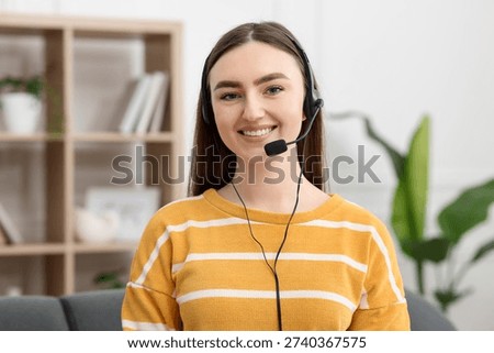 Portrait of smiling hotline operator in headset in office