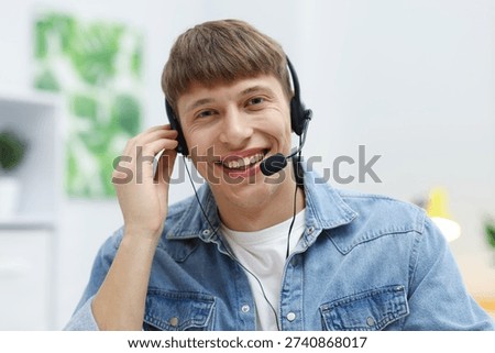 Portrait of smiling hotline operator in headset in office