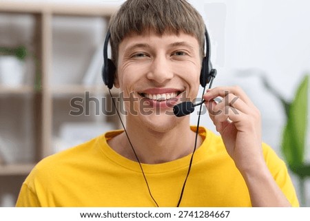 Portrait of smiling hotline operator in headset in office