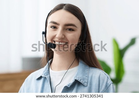 Portrait of smiling hotline operator in headset in office