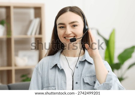 Portrait of smiling hotline operator in headset in office