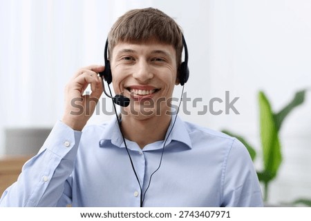 Portrait of smiling hotline operator in headset in office