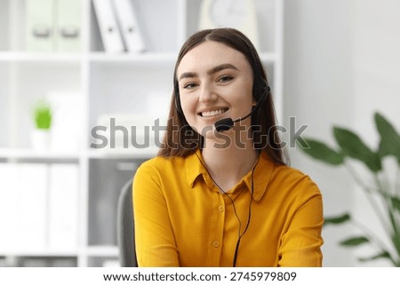Portrait of smiling hotline operator in headset in office