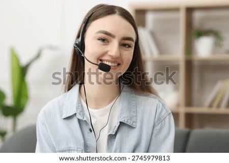 Portrait of smiling hotline operator in headset in office