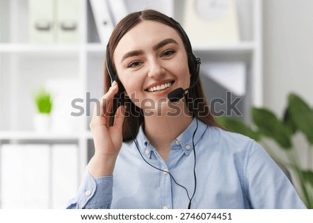 Portrait of smiling hotline operator in headset in office