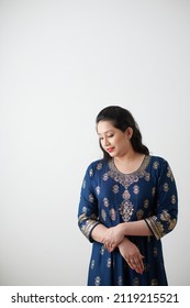 Portrait Of Smiling Humble Woman In Blue Dress Looking Down, Isolated On White