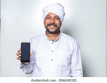 portrait of Smiling Indian farmer with phone in hand 