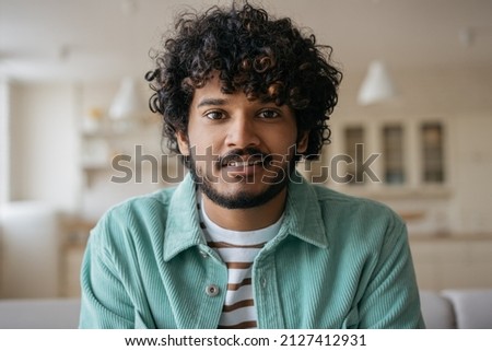 Portrait of smiling Indian student listening online lesson sitting at home. Handsome asian man having video call, communication online. Video conference concept
