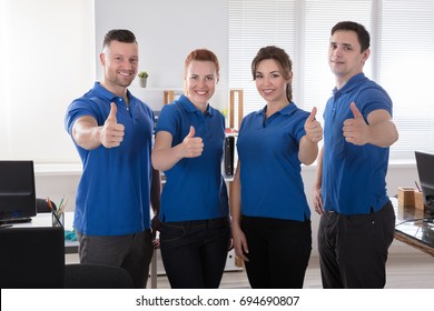 Portrait Of A Smiling Janitors Showing Thumb Up Sign In The Office