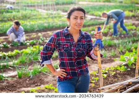 Portrait of smiling Latin American woman ready to work in her home garden on sunny autumn day