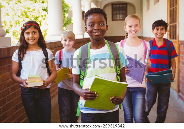 Portrait\
of smiling little school kids in school\
corridor