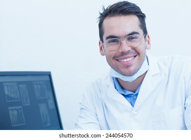 Portrait Of Smiling Male Dentist With Computer Monitor