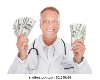 Portrait of smiling male doctor holding banknotes over white background