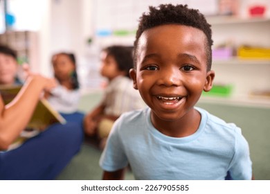 Portrait Of Smiling Male Elementary School Pupil Sitting In Classroom At School - Powered by Shutterstock