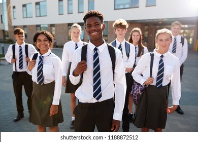 Portrait Of Smiling Male And Female High School Students Wearing Uniform Outside College Building