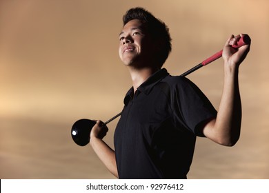 Portrait Of Smiling Male Golfer In Black Shirt Posing With Driver On Shoulders At Sunset.