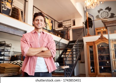 Portrait Of Smiling Male Owner Of Fashion Store Standing In Front Of Clothing Display