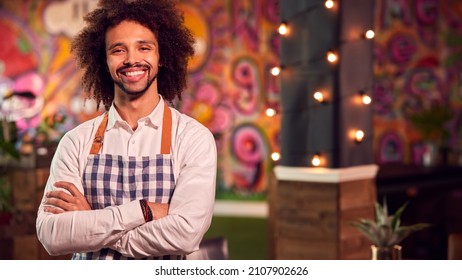 Portrait Of Smiling Male Server Working Night Shift In Bar Restaurant Or Club