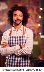 Portrait Of Smiling Male Server Working Night Shift In Bar Restaurant Or Club