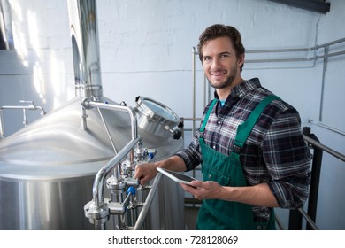 Portrait of smiling male worker using digital tablet at factory - Powered by Shutterstock