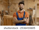 Portrait of smiling man carpenter in coveralls holding drill power tool