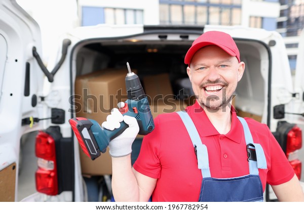 Portrait of\
smiling man with drill in his\
hands