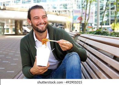 Portrait Of Smiling Man Eating Chinese Take Away Food