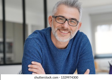 Portrait of smiling man with grey hair and glasses