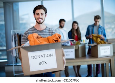 Portrait Of Smiling Man Holding A Donation Box In Office