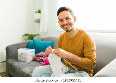 Portrait Of A Smiling Man Holding Knitting Needles And Doing A Wool Scarf As Part Of His Hobby To Keep A Positive Mental Health