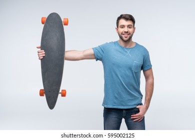 portrait of smiling man holding skateboard in hands isolated on white